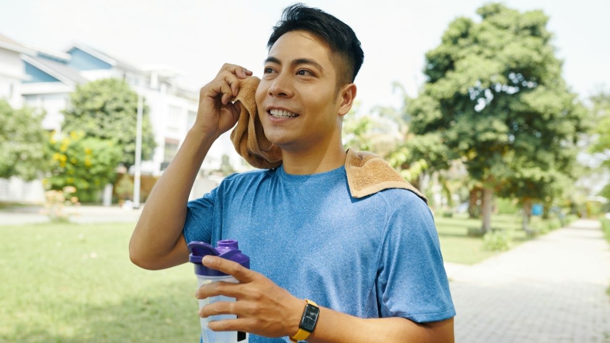 Seseorang menjaga stamina dengan minum air putih saat cuaca ekstrem matahari terik